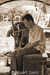 Old meets new. A long tail boat driver makes a phone call... by Stuart Ganz 